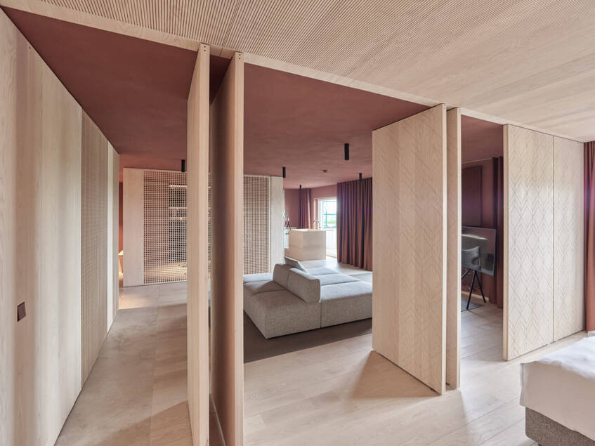 alt: "materialiedesign-fritsjurgens-system_M_reiters_supreme_suite_behf-architects_foto_kurt.hoerbst_porte_bilico_apertura_camera_albergo"