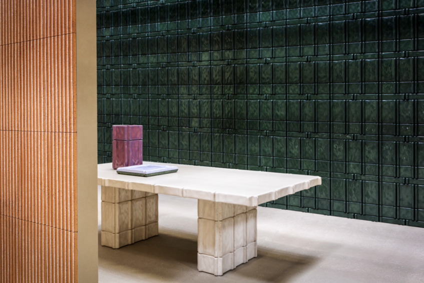 alt: "materialiedesign-cersaie-2025-tendenze-trend-ceramica-cimento-stand - tavolo"